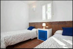 a bedroom with two beds and a lamp on a table at Las Casillas Del Cabo in Las Hortichuelas