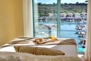 a bed with a tray of food and a glass of orange juice at Marina Ocean Residence in Albufeira