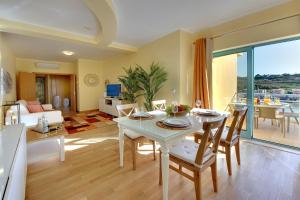 アルブフェイラにあるMarina Ocean Residenceのテーブルと椅子のあるキッチンとリビングルーム