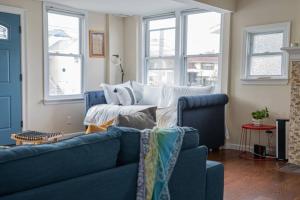 ein Wohnzimmer mit einem blauen Sofa und Fenstern in der Unterkunft NEW 4BR in AC Quiet Island Central Location in Atlantic City