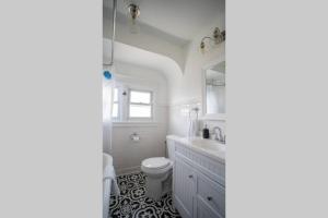 ein Badezimmer mit einem Waschbecken, einem WC und einem Spiegel in der Unterkunft NEW 4BR in AC Quiet Island Central Location in Atlantic City