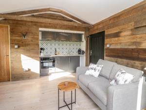 a living room with a couch and a table at Deer lodge at Chapel Lodges in Wimborne Minster