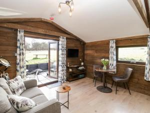 a living room with a couch and a table at Deer Lodge in Wimborne Minster