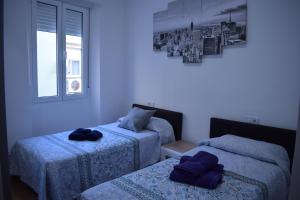 1 dormitorio con 2 camas y ventana en Los Tilos Apartments en Málaga