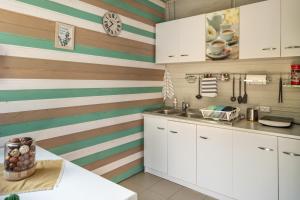 a kitchen with striped walls and white cabinets at Dragonfly Gardens Urban Glamping Brasov in Braşov +71 photos