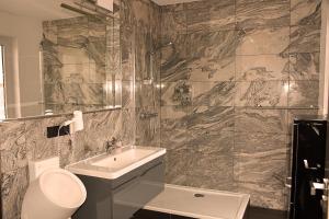 a bathroom with a sink, mirror, and bathtub at Hotel Walsroder Hof in Walsrode