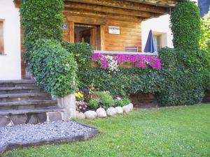 a house with a staircase and flowers in front of it at Haus Gstrein in Oetz