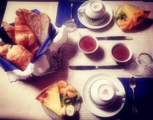 a table topped with plates of food and cups of tea at Angoville44 in Angoville-au-Plain