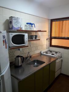 una pequeña cocina con fregadero y microondas en Departamento para 6 personas San Bernardo en San Bernardo