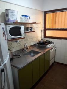 una pequeña cocina con fregadero y microondas en Departamento para 6 personas San Bernardo en San Bernardo