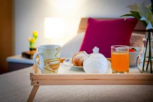 un vassoio di cibo e succo d'arancia su un letto di F&R Apartments a Rovigno (Rovinj)