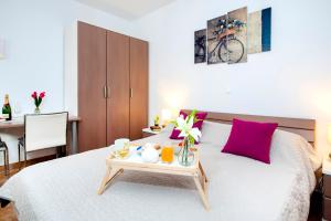 una camera da letto con un letto e un vassoio di cibo sopra di F&R Apartments a Rovigno (Rovinj)