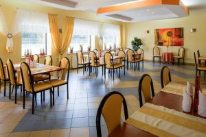 a dining room with tables and chairs and windows at Motel LESTA in Lachówka Duża