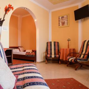 a living room with a bed and two chairs at Motel LESTA in Lachówka Duża