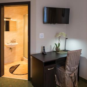 a room with a desk and a bathroom with a shower at Motel LESTA in Lachówka Duża