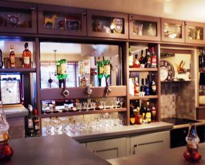 un bar con muchas botellas y vasos en Herlihy's, Half-Way-House en Farranfore