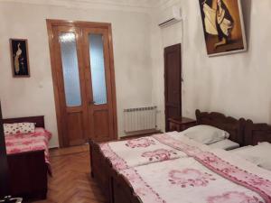 a bedroom with two beds and a wooden door at Hotel Kharabadze in Kutaisi