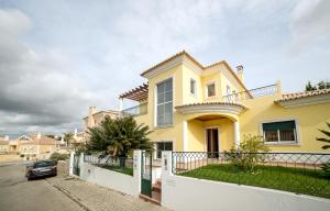 ein gelbes Haus mit einem davor geparkt in der Unterkunft Laguna Formosa - Holidays in Algarve in Faro