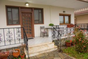 a house with a staircase leading to a door at Stefanie's Rooms in Asprovalta