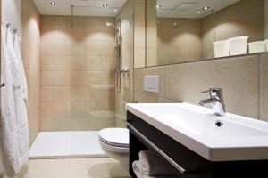 Un baño con lavabo, inodoro y ducha. en Hotel Wieser, en Mittersill