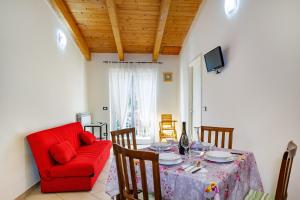 sala de estar con mesa y silla roja en Intero appartamento Fronte mare Valter II, en Silvi Paese