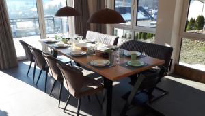 a dining room table with chairs and a large window at Villa Silberberg in Winterberg