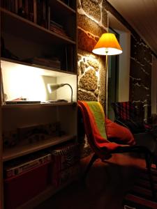 ヴィーラ・ノーヴァ・デ・ファマリカンにあるCasa Ana Monteiroの部屋の椅子の横に座るランプ