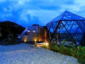 a glass house on the beach at night at Nacimiento Glamping in San Agustín