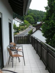 a patio with a table and chair on a balcony at Hotel Tannenhof in Erlenbach am Main