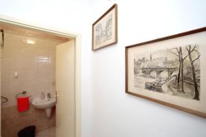 a bathroom with a painting on the wall and a sink at Apartmani Dubravka in Bibinje +48 photos