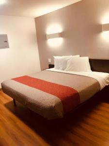 1 dormitorio con 1 cama grande con almohadas blancas en Motel 6-Augusta, GA - Fort Gordon, en Augusta