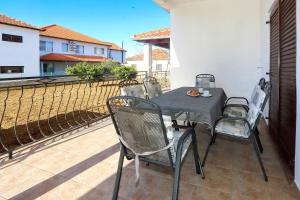 a black table and chairs on a balcony at Apartmani Dubravka in Bibinje