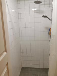 a bathroom with a shower with white tiles at IzKaMaGe Hotel in Västerås