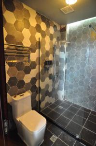 a bathroom with a toilet and a shower at Saipan Skyline Designers Hotel in Saipan