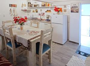 a kitchen with a table with chairs and a refrigerator at Ilio Socrates in Skala Marion