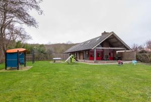 una pequeña casa con parque infantil en un patio en Welcome in - Zonnevylle, en Zoutelande