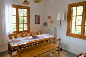a dining room with a table and chairs and windows at Evergreen Elati in Elati Trikalon