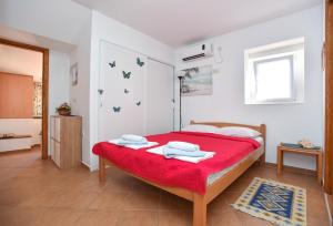 a bedroom with a bed with a red blanket at Sailor House in Budva