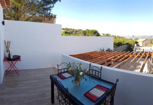 d'une terrasse avec une table bleue et un mur blanc. dans l'établissement Villa T3 à 10' de Cassis SPA - Jacuzzi, à Carnoux-en-Provence