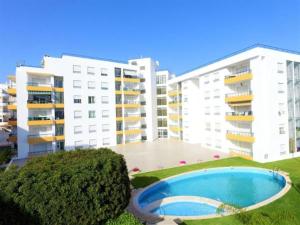 アルマカオ・デ・ペラにあるQuiet apartment overlooking the swimming poolの2棟の大きな建物とスイミングプールの景色を望めます。