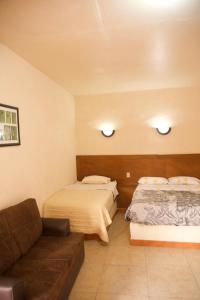 a hotel room with two beds and a couch at Hotel Cuauhtemoc in Quer&eacute;taro