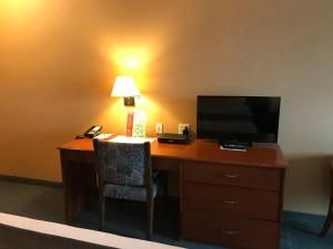 a desk in a hotel room with a television and a lamp at Beach Gardens Resort and Marina in Powell River +20 photos