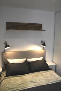 um quarto com uma cama com duas luzes por cima em Rez de Jardin Terrasse Literie Haut de gamme Proche Gare et Hyper Centre em Quimper