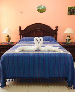 two swans forming a heart on a bed at Hotel Maria's Nicte Ha in Progreso