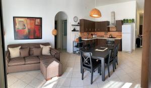 sala de estar y cocina con sofá y mesa en Corso Senatore Matarazzo 145 Apartment con terrazzo en Santa Maria di Castellabate