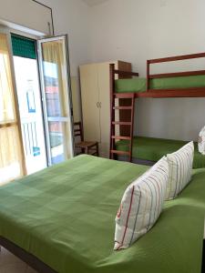 1 dormitorio con 1 cama verde y literas en Corso Senatore Matarazzo 145 Apartment con terrazzo en Santa Maria di Castellabate