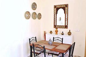 a dining room with a table and chairs and a mirror at Azra Homes Famille uniquement in Saïdia