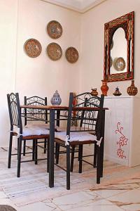 een eettafel met stoelen en een spiegel bij Azra Homes Famille uniquement in Saidia 