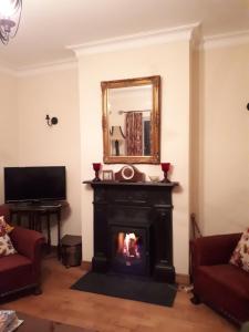 a living room with a fireplace and a mirror at Conways B&B in Claremorris