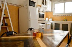 Il comprend une cuisine équipée d'une table en bois et d'un réfrigérateur blanc. dans l'établissement Cosy Triplex in La Marsa - 3 bed 2 Bath, à La Marsa